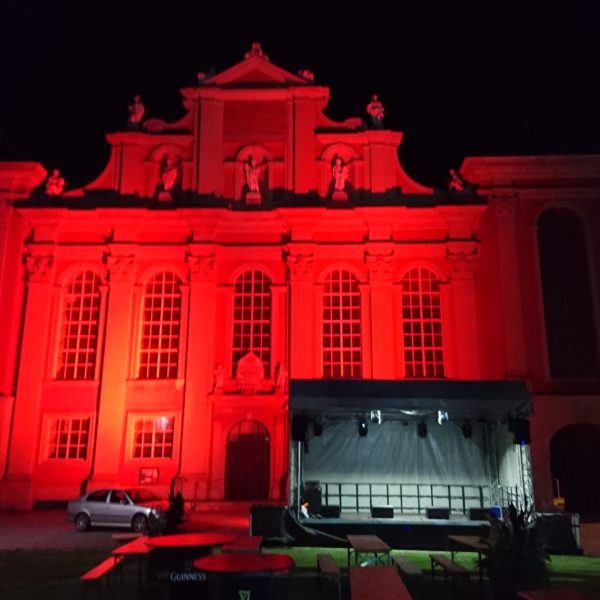 Altstadtfest Wolfenbüttel, rot illuminierte Trinitatis-Kirche, im Vorgrund 6 x 4 m Pultdachbühne im Rohbau